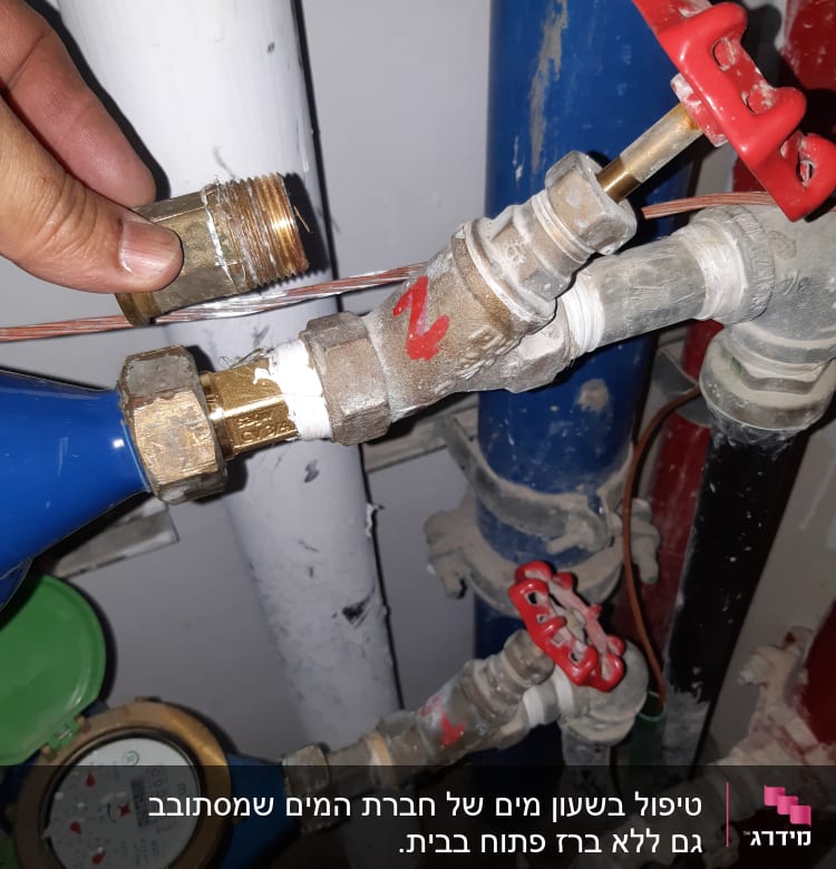 יד מחזיקה מחבר פליז ליד ברזים וצינורות